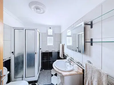 a white bathroom with a sink and a shower at Apartamento Bela Vista in Calheta