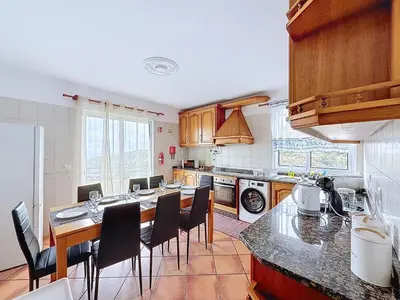a kitchen with a table and some chairs in it at Apartamento Bela Vista in Calheta