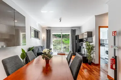 a living room with a dining room table and a couch at Brisa do Caniço in Caniço