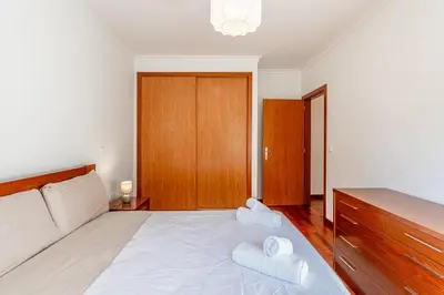 a bedroom with a bed with two towels on it at Brisa do Caniço in Caniço