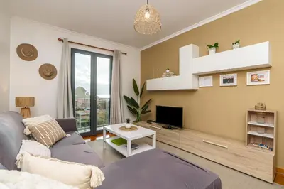 a living room with a couch and a tv at Chill'Inn Madeira in Santa Cruz