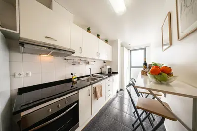 a kitchen with white cabinets and a counter with a bowl of oranges at Chill'Inn Madeira in Santa Cruz