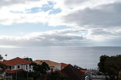 a view of the ocean with houses and buildings at Chill'Inn Madeira in Santa Cruz