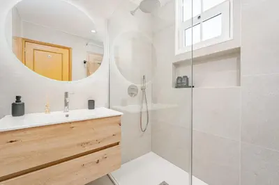 a bathroom with a shower and a sink and a mirror at JPL - Preces Residential in Câmara de Lobos