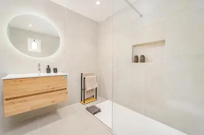 a white bathroom with a sink and a mirror at JPL - Preces Residential in Câmara de Lobos