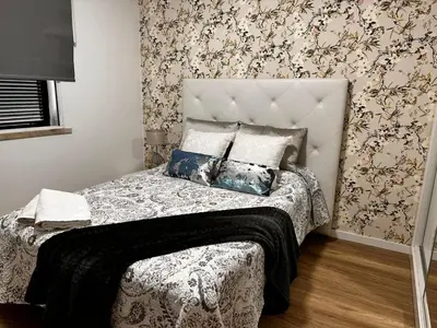 a bedroom with a bed with a floral wallpaper at Casa de Ferias dos Marmeleiros in Funchal
