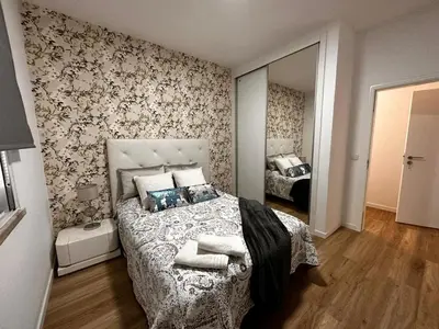 a bedroom with a bed and a mirror at Casa de Ferias dos Marmeleiros in Funchal
