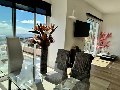 a dining room with a glass table and a vase with flowers at Casa de Ferias dos Marmeleiros in Funchal