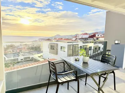 a table and chairs on a balcony with a view of the ocean at Atlantic Harmony Residence in Funchal