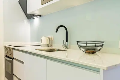 a white kitchen with a sink and a counter top at Nobregas Lodge in Senhora do Rosário