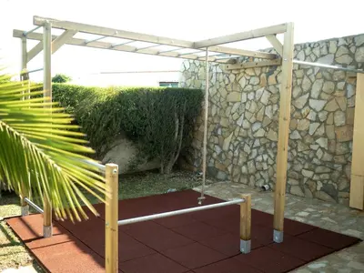 a patio with a stone wall and a pergola at Sunset Hideaway - a private paradies in Aljezur
