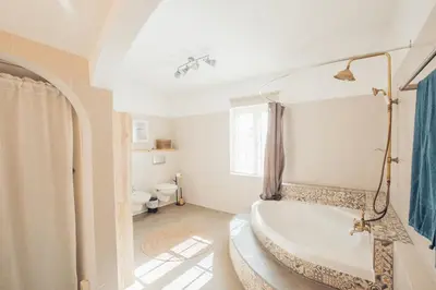 a white bathroom with a tub and a toilet at Sunset Hideaway - a private paradies in Aljezur