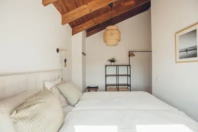 a bedroom with a white bed and a wooden ceiling at Sunset Hideaway - a private paradies in Aljezur