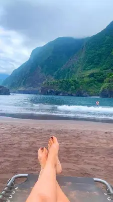 a person with their feet up on a beach at Loft - Villa Casa do mar in Ponta Delgada