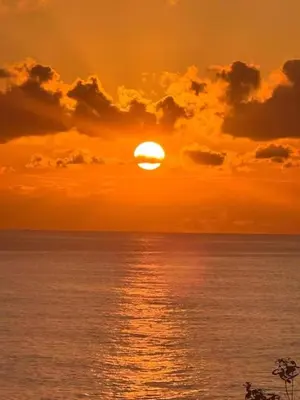 a sunset over the ocean with the sun at Loft - Villa Casa do mar in Ponta Delgada