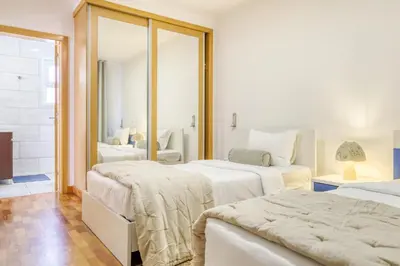 a bedroom with two beds and a mirror at Ponta do Sol Sea View, a Home in Madeira in Ponta do Sol