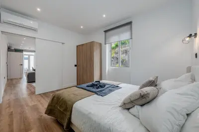 a white bedroom with a large bed and a window at Stylish 1 Bed Room in Funchal
