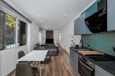 a kitchen and living room with a table and a couch at Stylish 1 Bed Room in Funchal