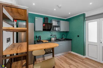 a kitchen with green walls and a wooden counter at Stylish 1 Bed Room Studio Flat in Funchal