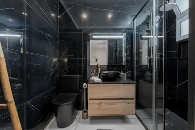 a black bathroom with a sink and a shower at Stylish 1 Bed Room Studio Flat in Funchal