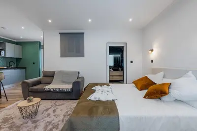 a bedroom with a large bed and a living room at Stylish 1 Bed Room Studio Flat in Funchal