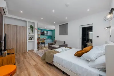 a bedroom with a large bed and a living room at Stylish 1 Bed Room Studio Flat in Funchal