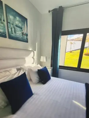 a bedroom with a bed with blue pillows and a window at Tranquil Escape in Gaula
