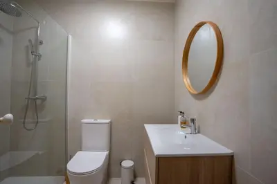 a bathroom with a toilet and a sink and a shower at Villa Jasmin by Atlantic Holiday in Caniço