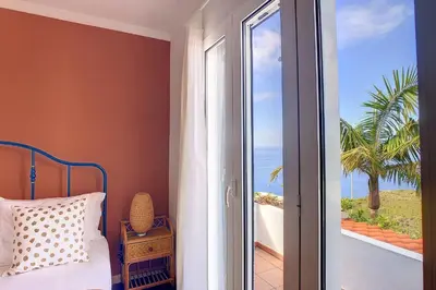 a bedroom with a bed and a view of the ocean at Villa Jasmin by Atlantic Holiday in Caniço