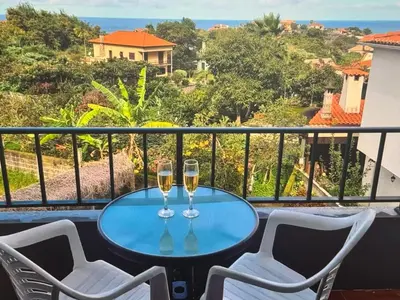 two glasses of wine sitting on a table on a balcony at Charming island in Ponta Delgada