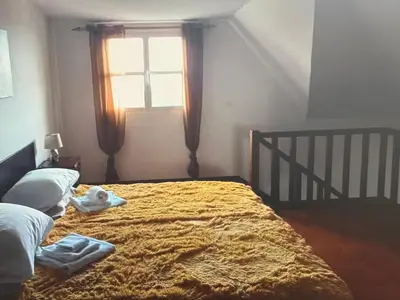 a bedroom with a large bed with a window at Charming island in Ponta Delgada