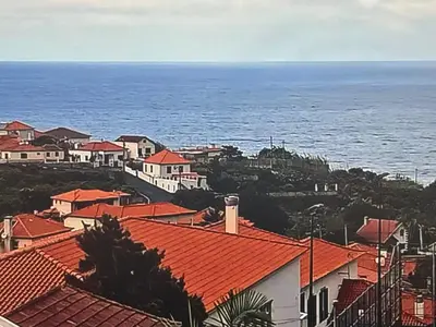 a view of a town with red roofs and the ocean at Charming island in Ponta Delgada