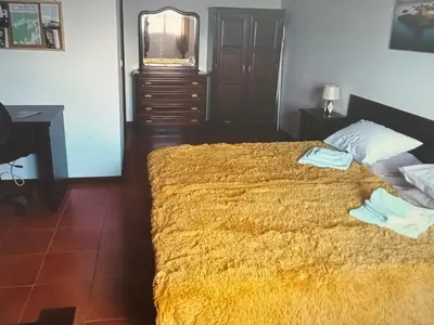 a bedroom with a bed and a desk and a television at Charming island in Ponta Delgada