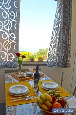 a table with a bowl of fruit and a bottle of wine at Villa Henriques in Funchal