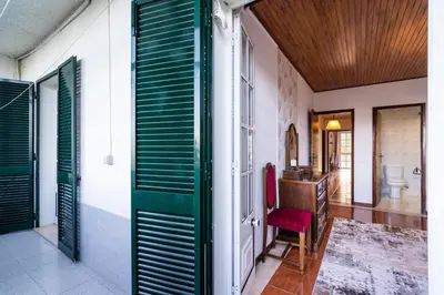 a bathroom with a toilet and a green door at GuestReady - Faia House in Gaula