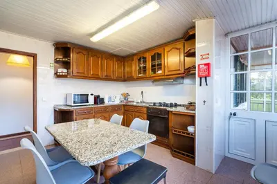 a kitchen with wooden cabinets and a table with chairs at GuestReady - Faia House in Gaula