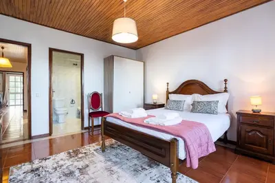a bedroom with a large bed and a bathroom at GuestReady - Faia House in Gaula