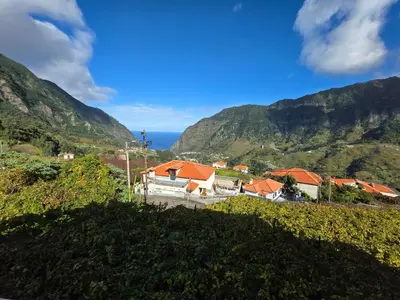 a village on a hill with mountains in the background at Villa Margarida São Vicente Madeira in São Vicente