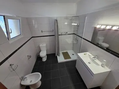a white bathroom with a sink and a toilet at Villa Margarida São Vicente Madeira in São Vicente
