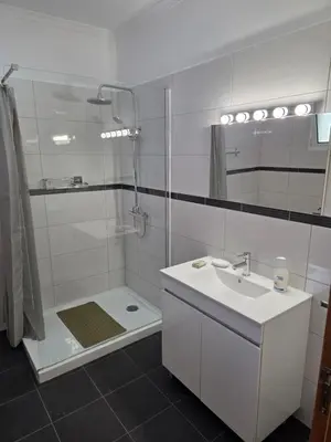 a white bathroom with a shower and a sink at Villa Margarida São Vicente Madeira in São Vicente