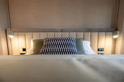 a bed with a headboard with a pillow on it at Cathedral Houses in Funchal