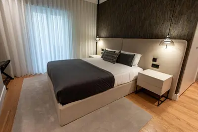 a bedroom with a large bed with a black blanket at Cathedral Houses in Funchal
