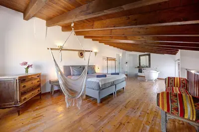 a bedroom with a bed and a wooden floor at House Fun Ride Surf School in Sagres