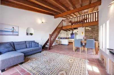 a living room with a couch and a table at House Fun Ride Surf School in Sagres