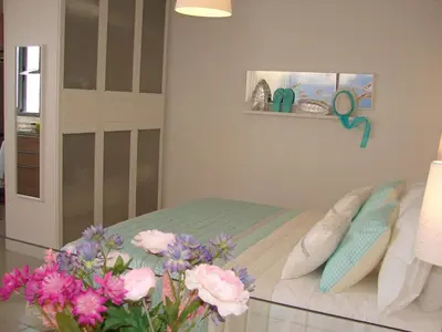 a bedroom with a bed and flowers on a glass table at Crystal Madeira Studio in Funchal