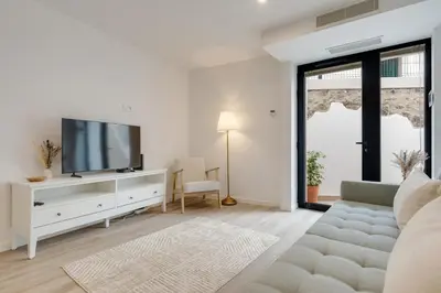a white living room with a tv and a couch at Mercy by the Sea by Holiday Rental Madeira in Machico