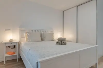 a white bed with two stuffed animals sitting on it at Mercy by the Sea by Holiday Rental Madeira in Machico