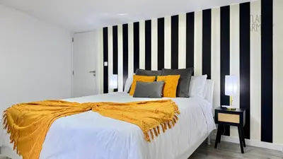 a bedroom with a bed with a black and white striped wall at Atlantic Harmony Residences in Funchal