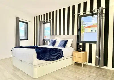 a bedroom with a large bed with striped walls at Atlantic Harmony Residences in Funchal