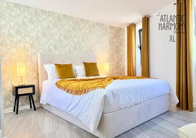 a bedroom with a large white bed with yellow pillows at Atlantic Harmony Residences in Funchal